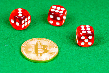 bitcoin metal coin with red dices on green cloth