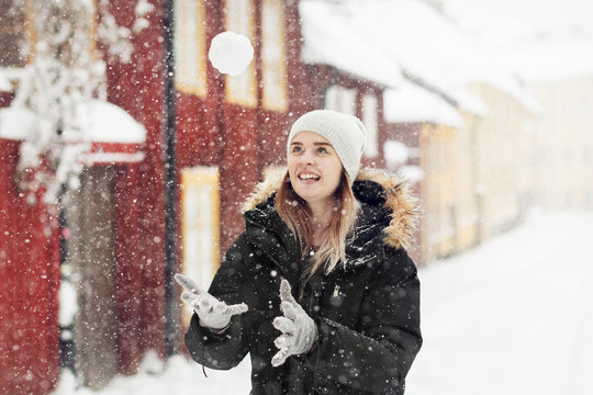 Smiling woman throwing snowball