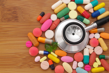 Many drugs and stethoscope on wooden table. healthcare concept