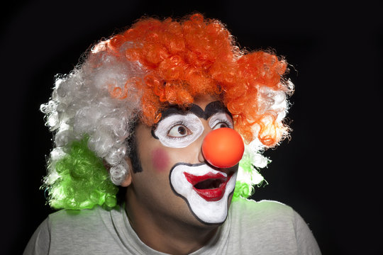 Surprise male clown over black background 