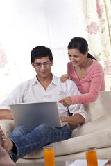 Obraz premium Young woman pointing at laptop while man using laptop 