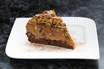 piece of chocolate caramel cake on a dark background