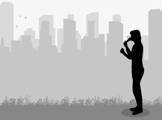 Silhouette of a singing man on a city background