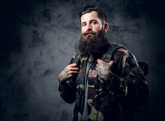 Bearded tattooed male in camouflage jacket.