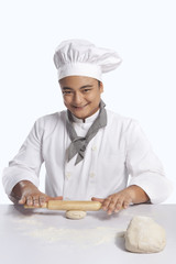 Portrait of chef rolling dough