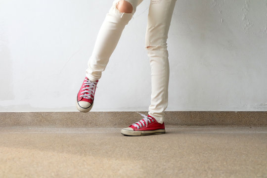 Closeup Photo of From Woman Wearing Red Sneakers On The Concrete Floor Background Great For Any Use.