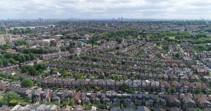 Aerial panning view of a typical Edwardian Victorian village with the skyline of the City of London in the background