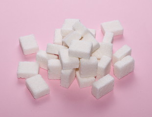 White sugar cubes isolated on pink background and texture
