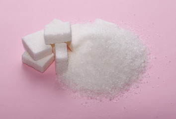 White sugar cubes and pile isolated on pink background and texture