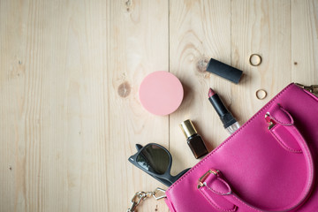 Top view of Women bag and lady stuff with copyspace on wooden background, vigtage effect photo