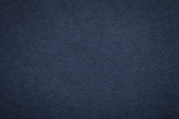 Texture of old navy blue paper background, closeup. Structure of dense dark denim cardboard