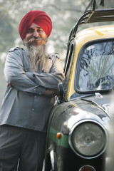 Sikh taxi driver standing next to his vehicle 