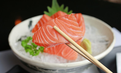 sashimi salmon on chopstick.