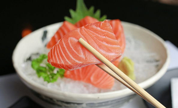 sashimi salmon on chopstick.