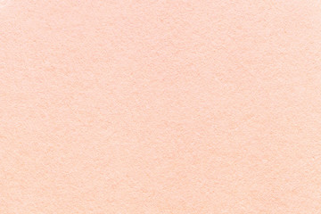 Texture of old light pink paper background, closeup. Structure of dense coral cardboard