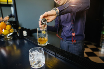 Bartender is making cocktail at bar.