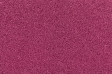 Texture of old purple paper background, closeup. Structure of dense magenta cardboard