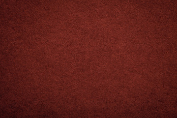 Texture of old dark red paper background, closeup. Structure of dense maroon cardboard