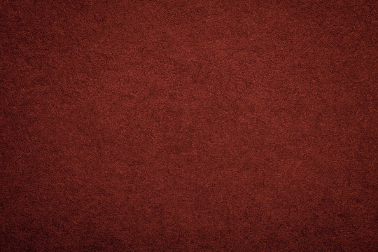 Texture of old dark red paper background, closeup. Structure of dense maroon cardboard