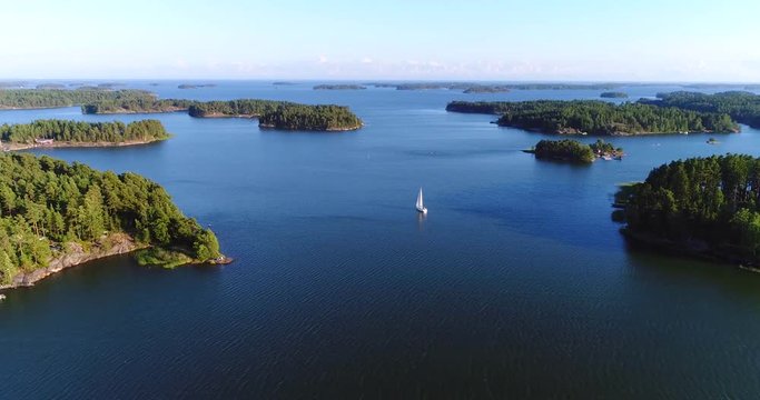 Sailboat in archipelago, Cinema 4k aerial view away from a sail boat, in uusimaa saaristo archipelago, on the gulf of finland, on a sunny evening dawn, in Raasepori, Finland