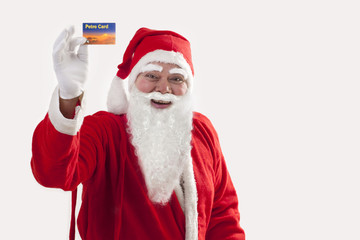 Cheerful Santa Claus showing petro card over colored background 