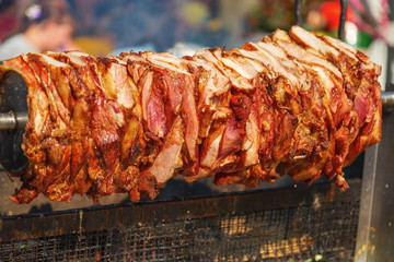 Large pieces of meat on a spit. Crilled skewered beef meat on spit.