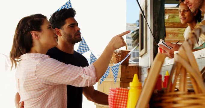 Smiling waiter taking order from couple