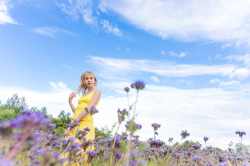 Fototapeta na wymiar Girl in purple flowers outdoors in summer