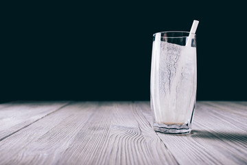 Empty glass with a straw from a smoothie on a black background