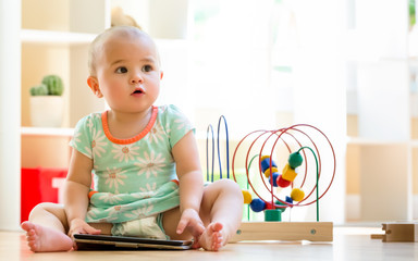 Toddler girl watching a tablet computer in her house