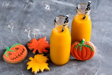 Two bottles of pumpkin juice with black straws Horizontal photo Halloween food and sweets Halloween background