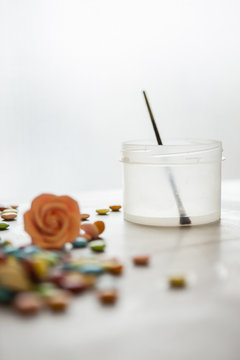 Food coloring brush in sugar water next to marzipan flower