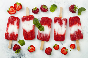 Homemade vegan strawberry coconut milk popsicles - ice pops - paletas on rustic white background