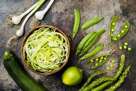 Zucchini spaghetti or noodles (zoodles) bowl with green veggies. Top view, overhead