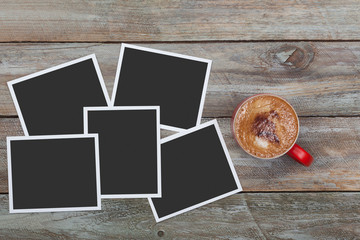 Red coffee mug and heap of instant photos