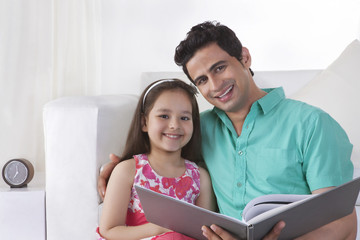 Fototapeta premium Portrait of father and daughter with file at home