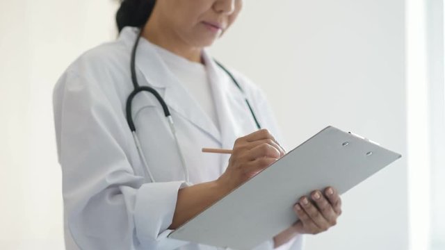 Professional concentrated female doctor making notes