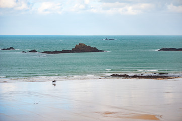 A man and a horse on an empty beach, Brittany, France