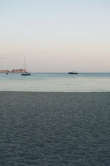 high angle format of beach in the evening with some sailing boats