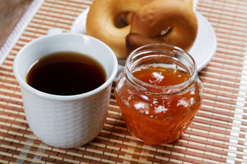 Jam jar and pretzel on the table close-up