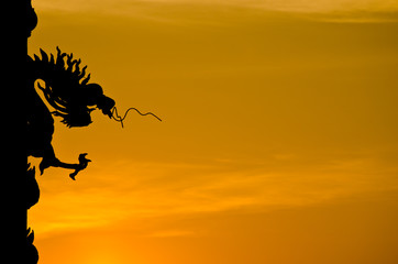 Naklejka na ściany i meble Chinese style Dragon statue silhouette with sunset.