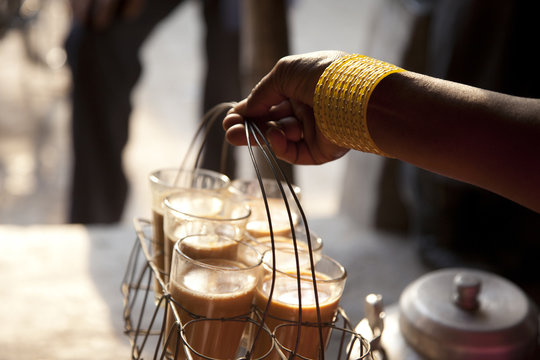 Close-up of female's hand holding tray of fresh morning chai 