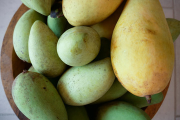 Detail and close-up of green and yellow mangoes in basket, thai mango