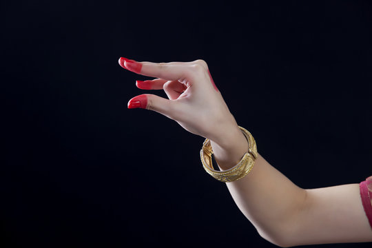Close-up of a woman's hand making Bharatanatyam gesture called Kangula on black background