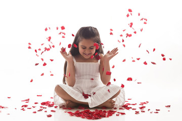 Obraz na płótnie Canvas Rose petals falling on a little girl 