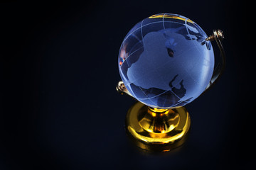 Glass globe model gold stand on black table background