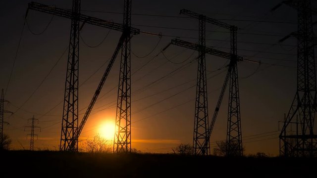 High-voltage power lines at sunrise. Time lapse.