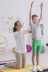 Boy exercising with physiotherapist