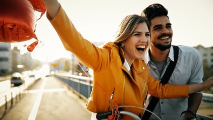 Young loving couple dating while riding bicycles in the city - Powered by Adobe