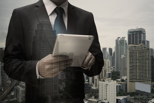 Double exposure of Businessman Using Digital Tablet